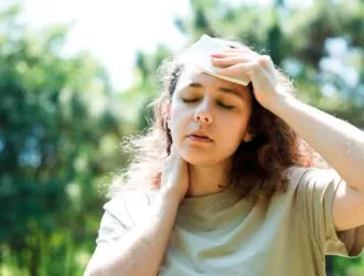mujer sintiéndose mal secándose el sudor